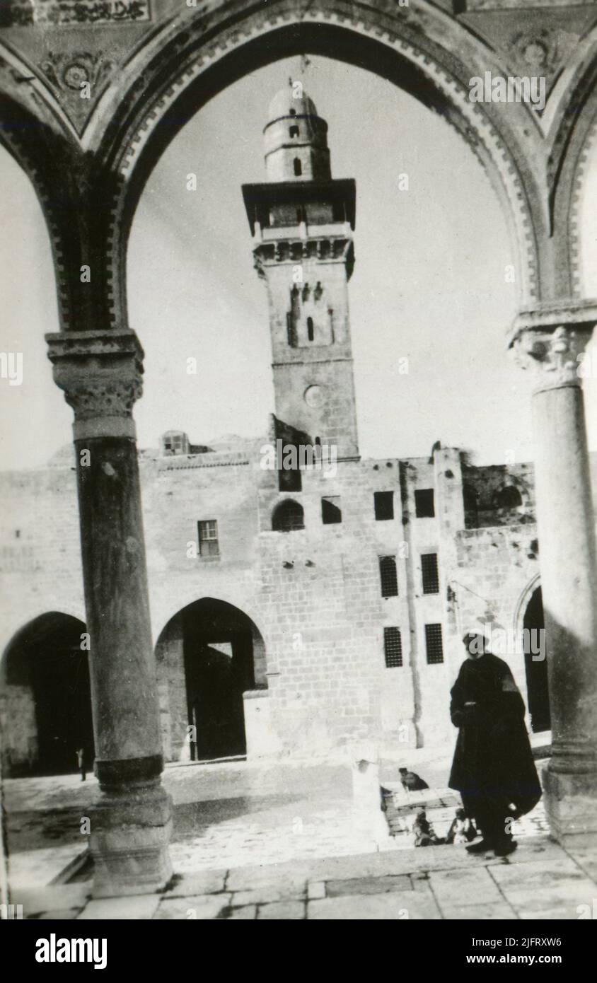 Un accompagnateur âgé debout devant le minaret Bab al-Silsila sur le mont du Temple dans la vieille ville de Jérusalem. 1930s Banque D'Images