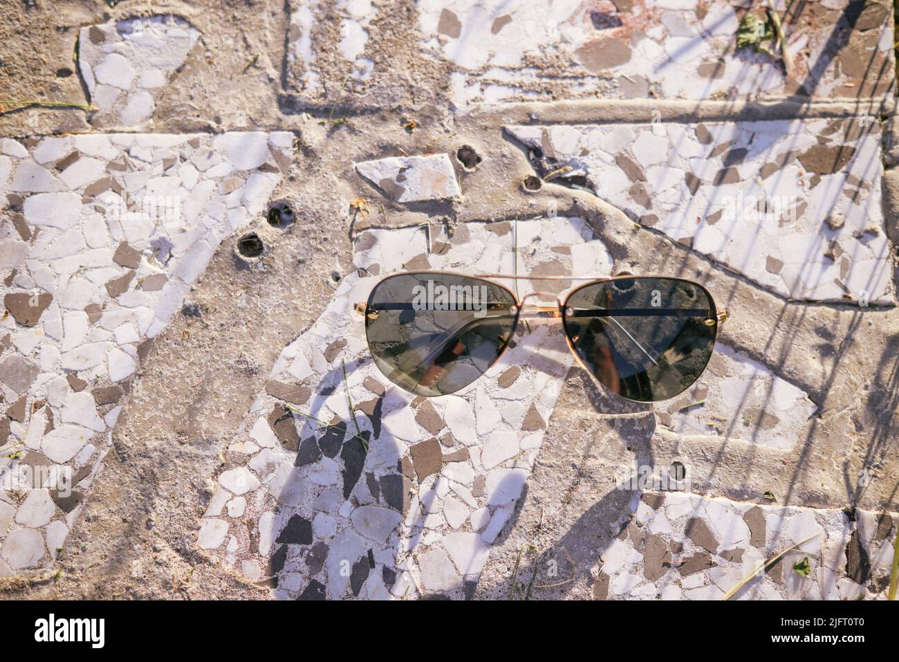 lunettes de soleil pour les magasins sur fond de pierre avec des rayons de lumière Banque D'Images