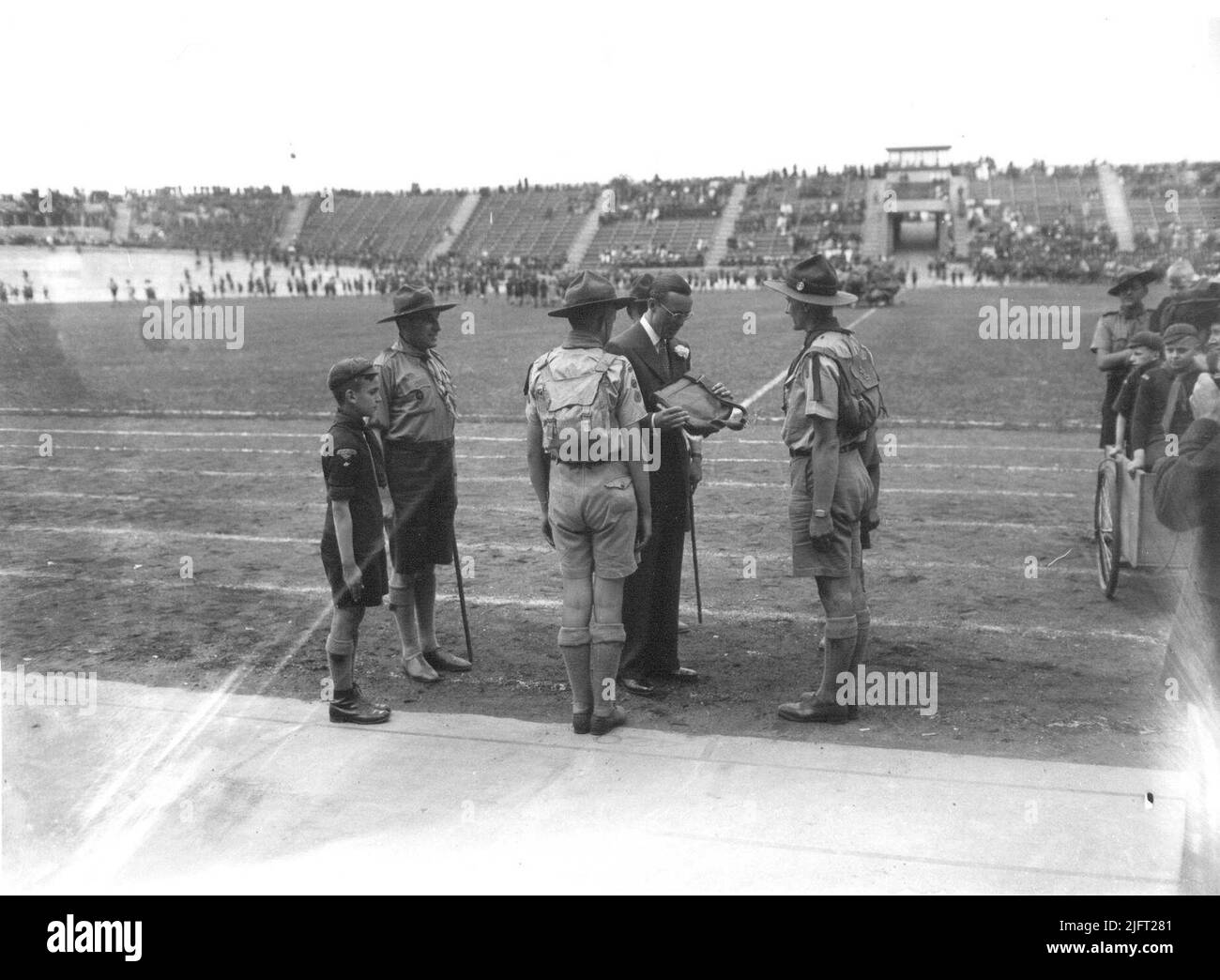Lors de l'ouverture du stade Goffert, le Prince Bernhard se fait offrir un sac à dos par un hopman des scouts. Banque D'Images
