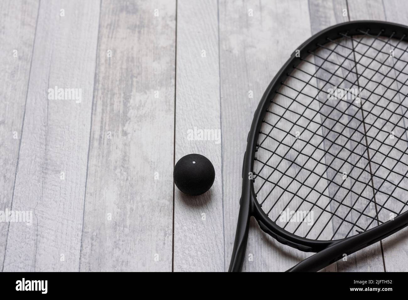 Raquette et balle de squash noires sur terrain gris. Affiche sur le thème du sport horizontal, cartes de vœux, en-têtes, site Web et application Banque D'Images