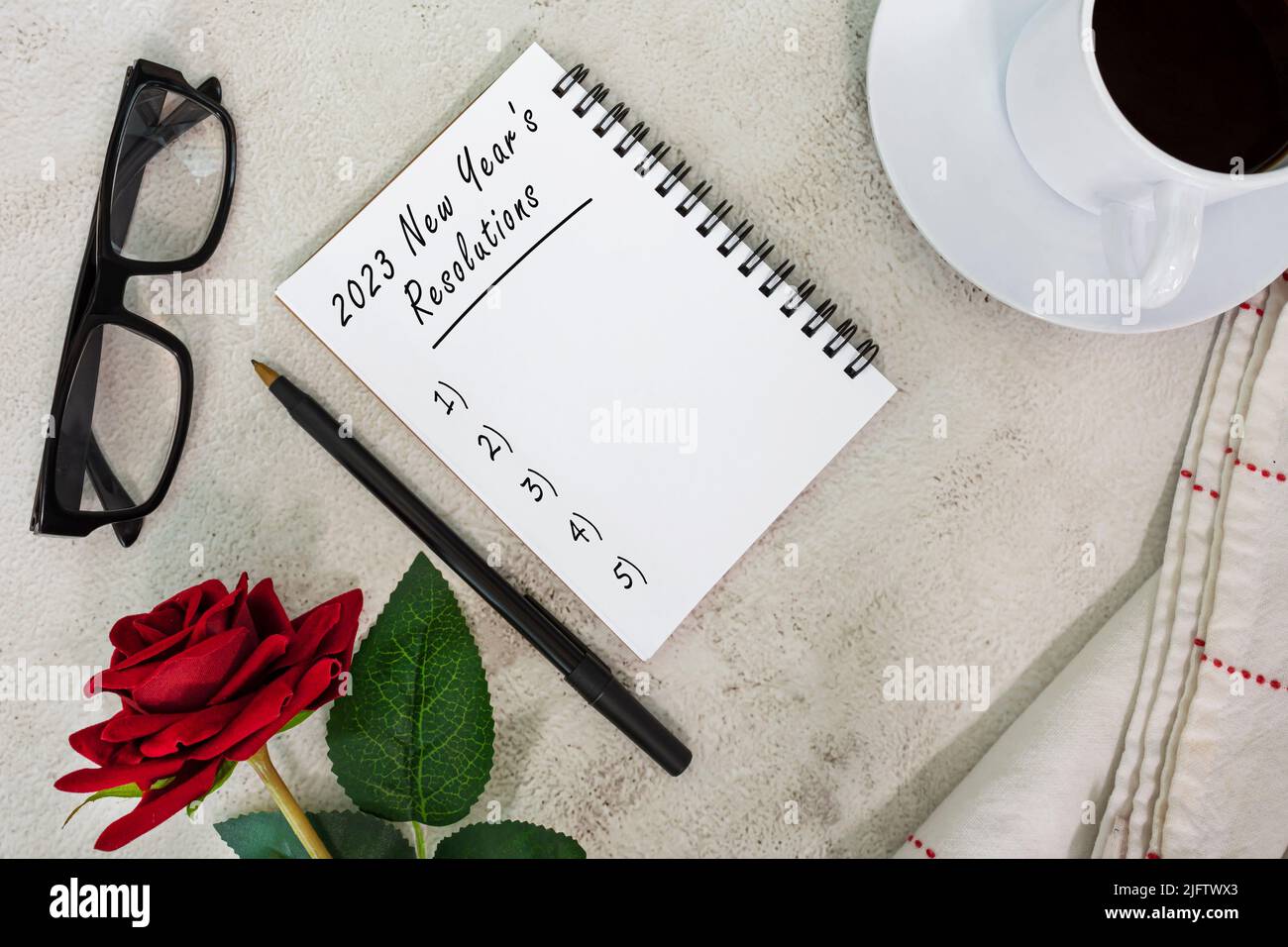 2023 résolutions du nouvel an écrites sur un carnet de notes sur une table en marbre blanc. Banque D'Images