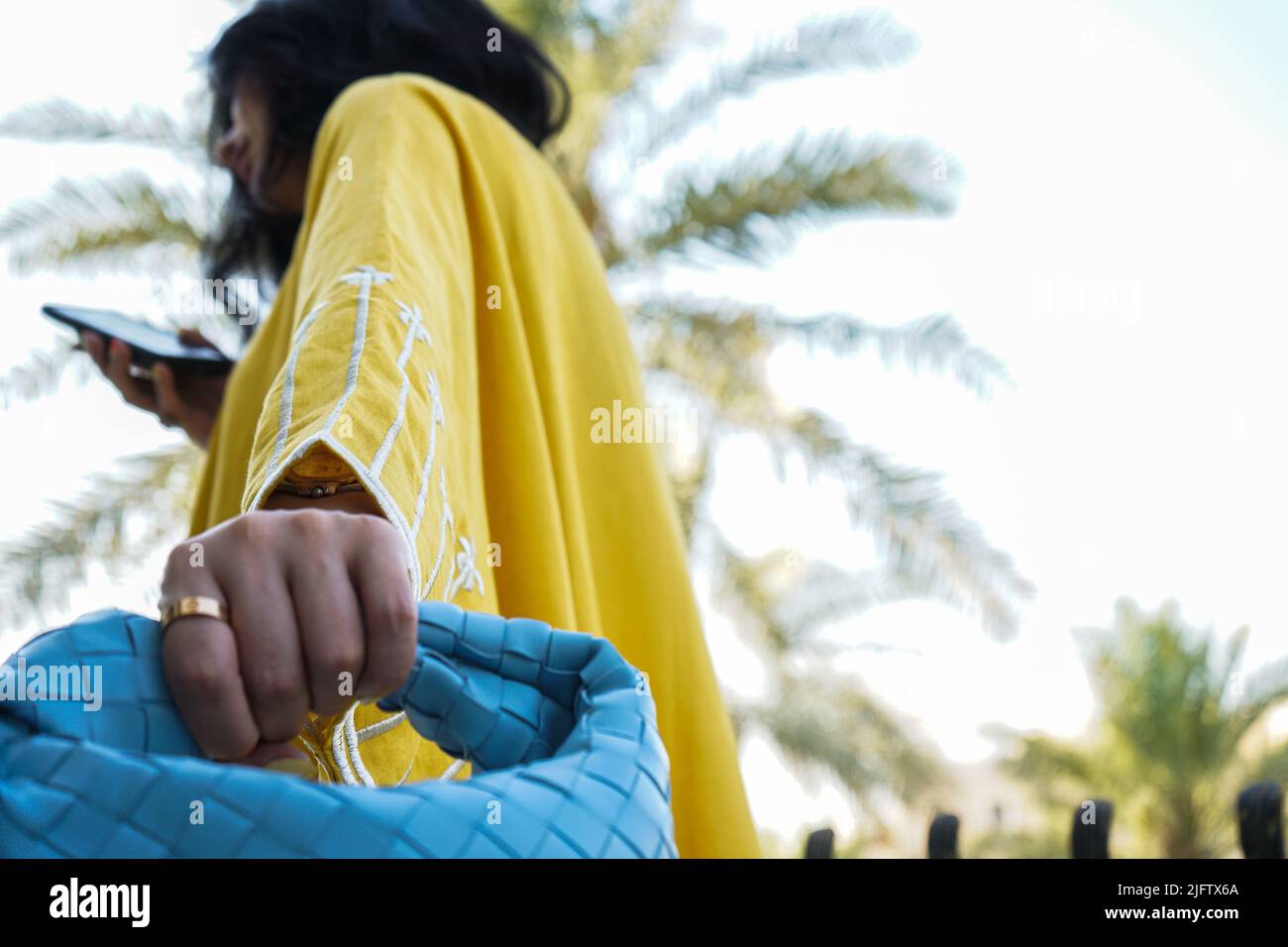 Femme portant l'Abaya jaune, Abaya saoudienne et tenant un sac. Banque D'Images