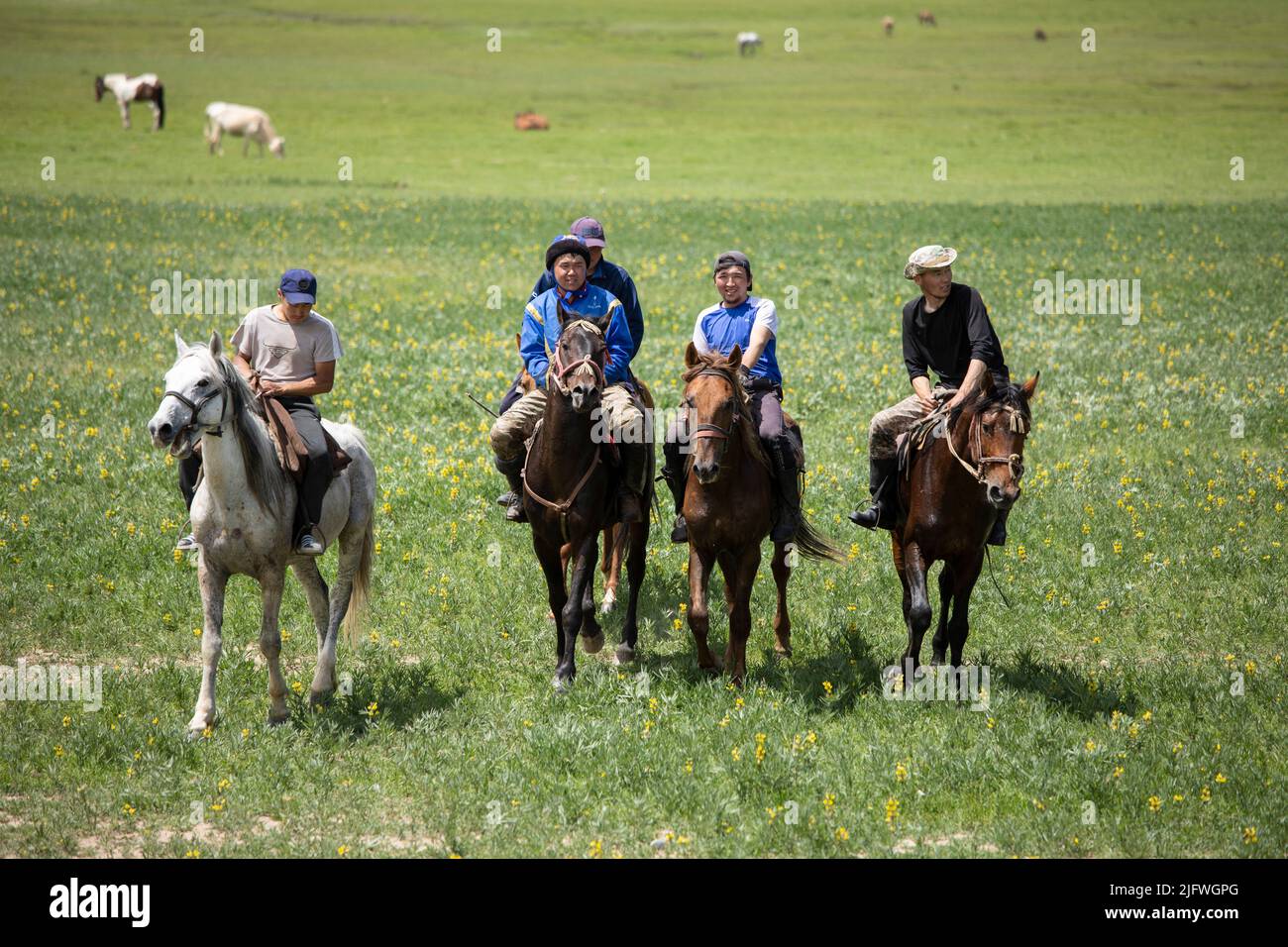 Les hommes jouent un match de Kok Boru, ou polo de chèvre mort, dans un champ au Kirghizistan. Banque D'Images