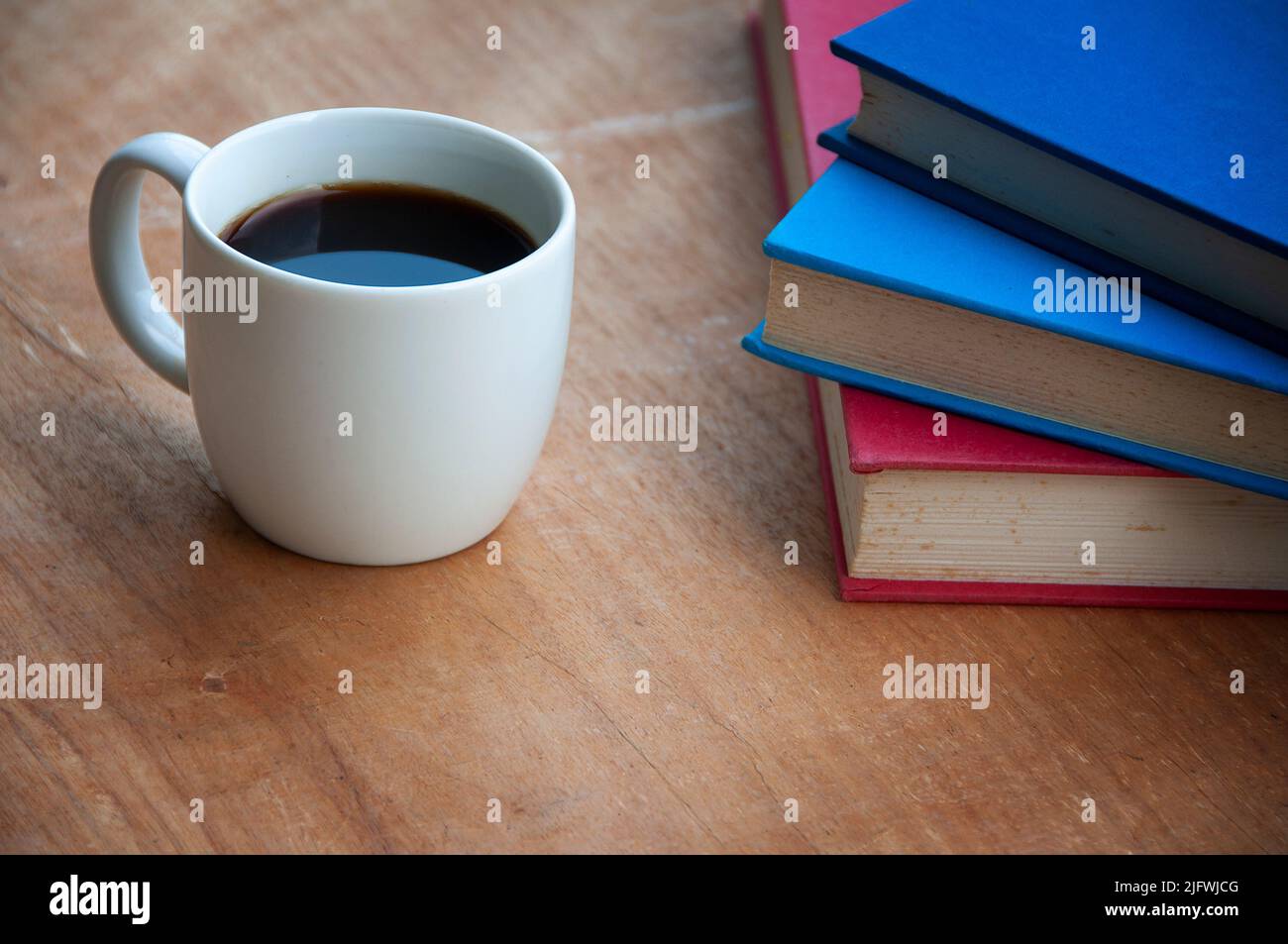Café avec livres sur le bureau en bois. Vue directe. Copier l'espace. Banque D'Images