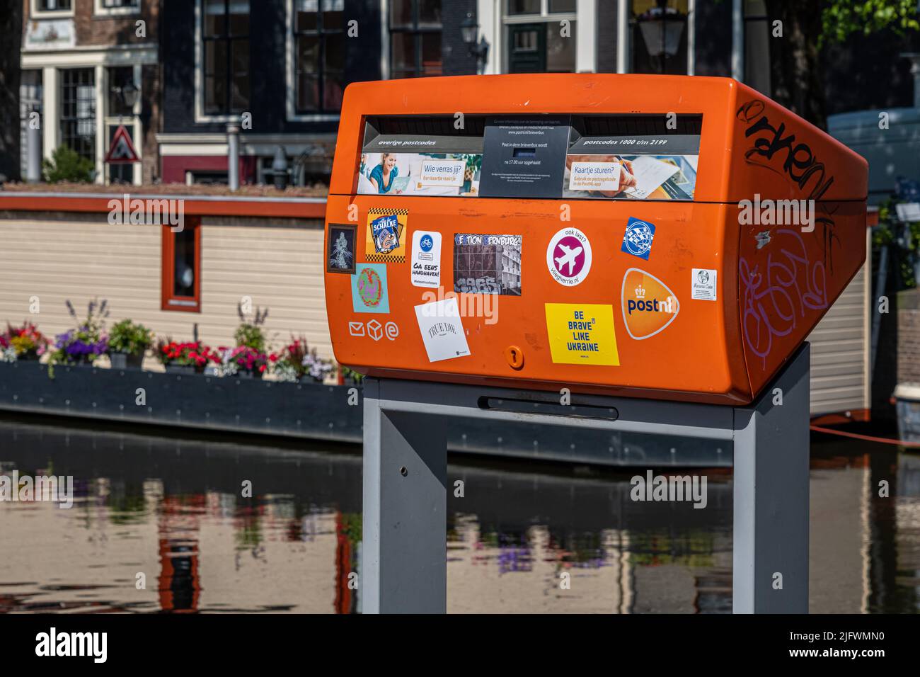 Amsterdam, pays-Bas - 23 juin 2022 : boîte postale rouge le long du canal Banque D'Images