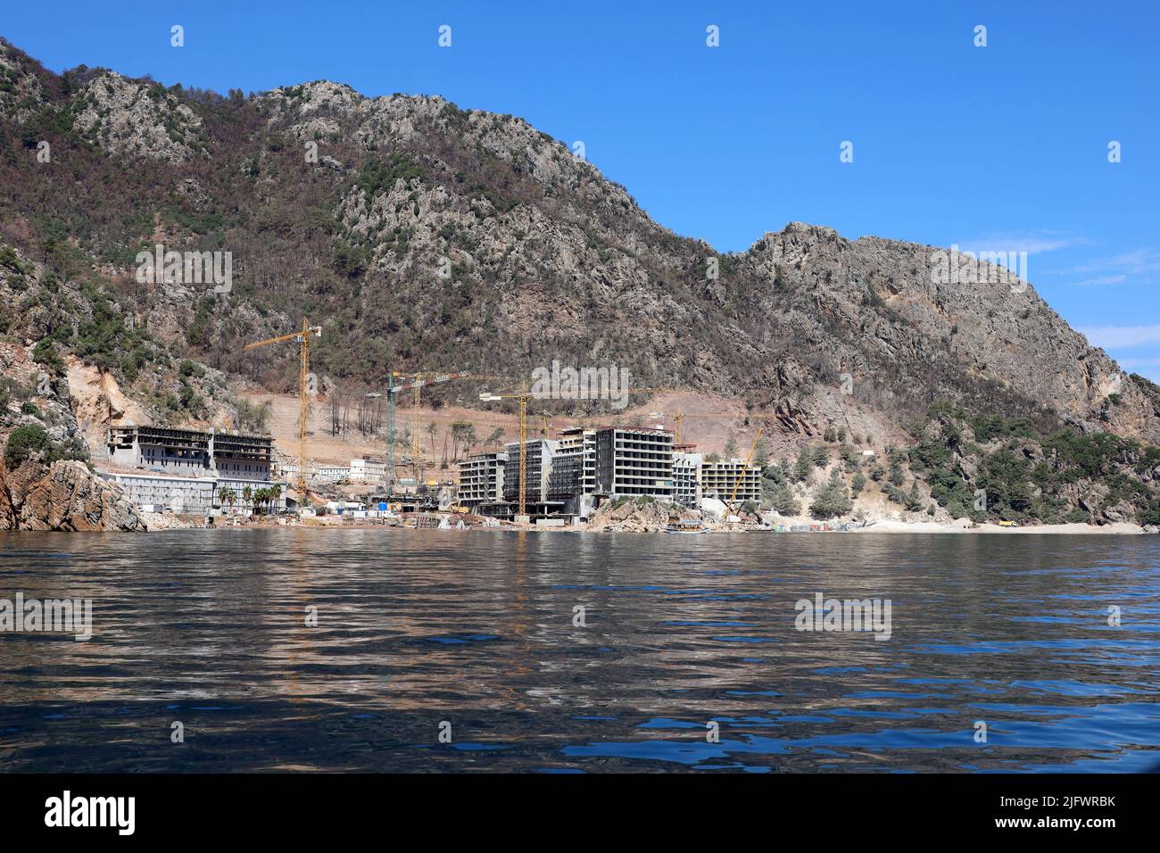 Construction de bâtiments d'hôtel sur une plage de montagne en mer Méditerranée. Développement de la station d'été en Turquie Banque D'Images