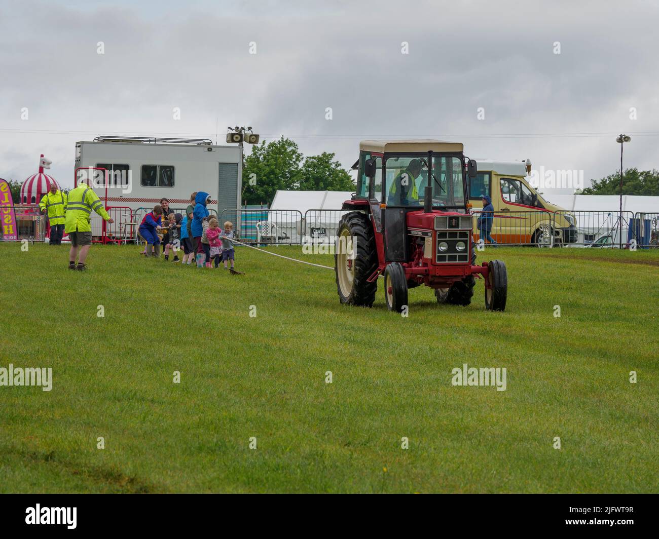Remords de guerre entre enfants et tracteur d'époque au Launceston Steam & Vintage Rally, Cornwall, Royaume-Uni Banque D'Images
