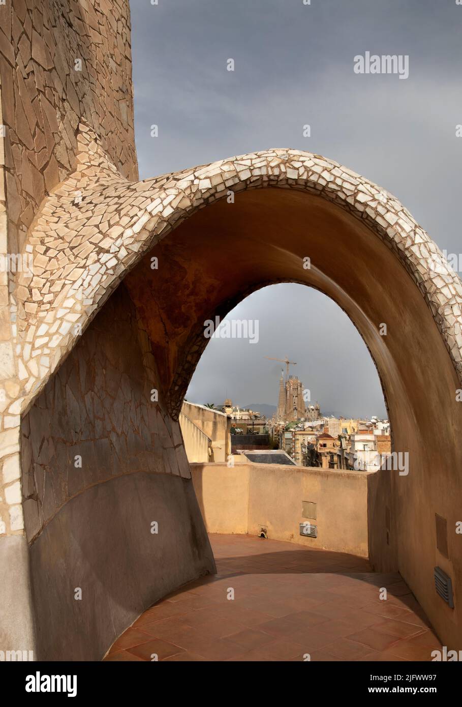 Cheminées et tours de ventilation, la Pedrera (Casa Milà, Antoni Gaudi, 1905-10), Barcelone, Catalunya, Espagne avec la Sagrada Familia à l'arrière Banque D'Images