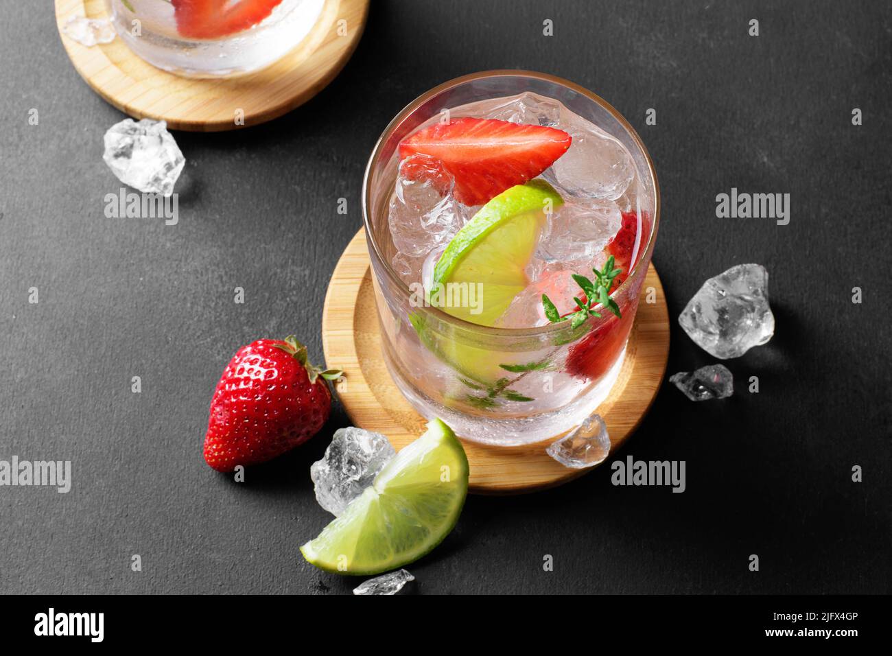 Une glasse à la boisson gazeuse aux fraises d'été ou un mojito à la fraise, aux glaçons et à la chaux sur fond clair Banque D'Images