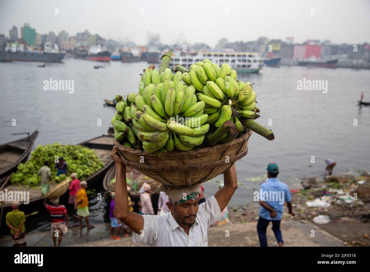 Les travailleurs sont occupés à décharger les fruits saisonniers des bateaux à Wiseghat, dans le vieux Dhaka. Bangladesh Banque D'Images