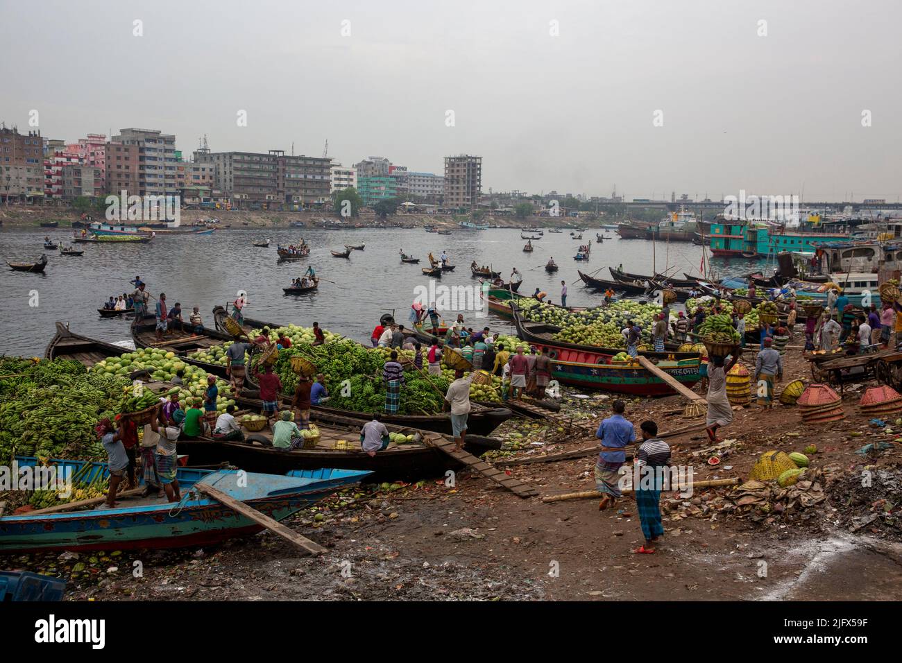 Les travailleurs sont occupés à décharger les fruits saisonniers des bateaux à Wiseghat, dans le vieux Dhaka. Bangladesh Banque D'Images