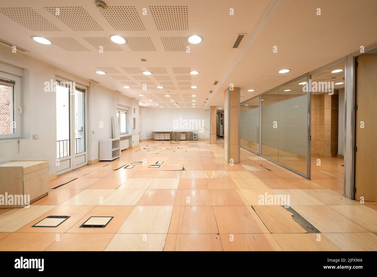 Grande salle pour les bureaux avec plancher technique nécessitant des améliorations et cloisons en acier et en verre Banque D'Images