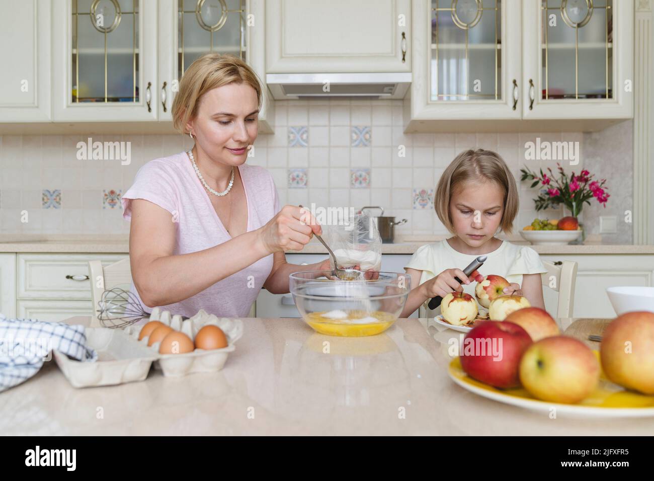 Maman et fille cuisent la tarte aux pommes ensemble dans la cuisine. Banque D'Images