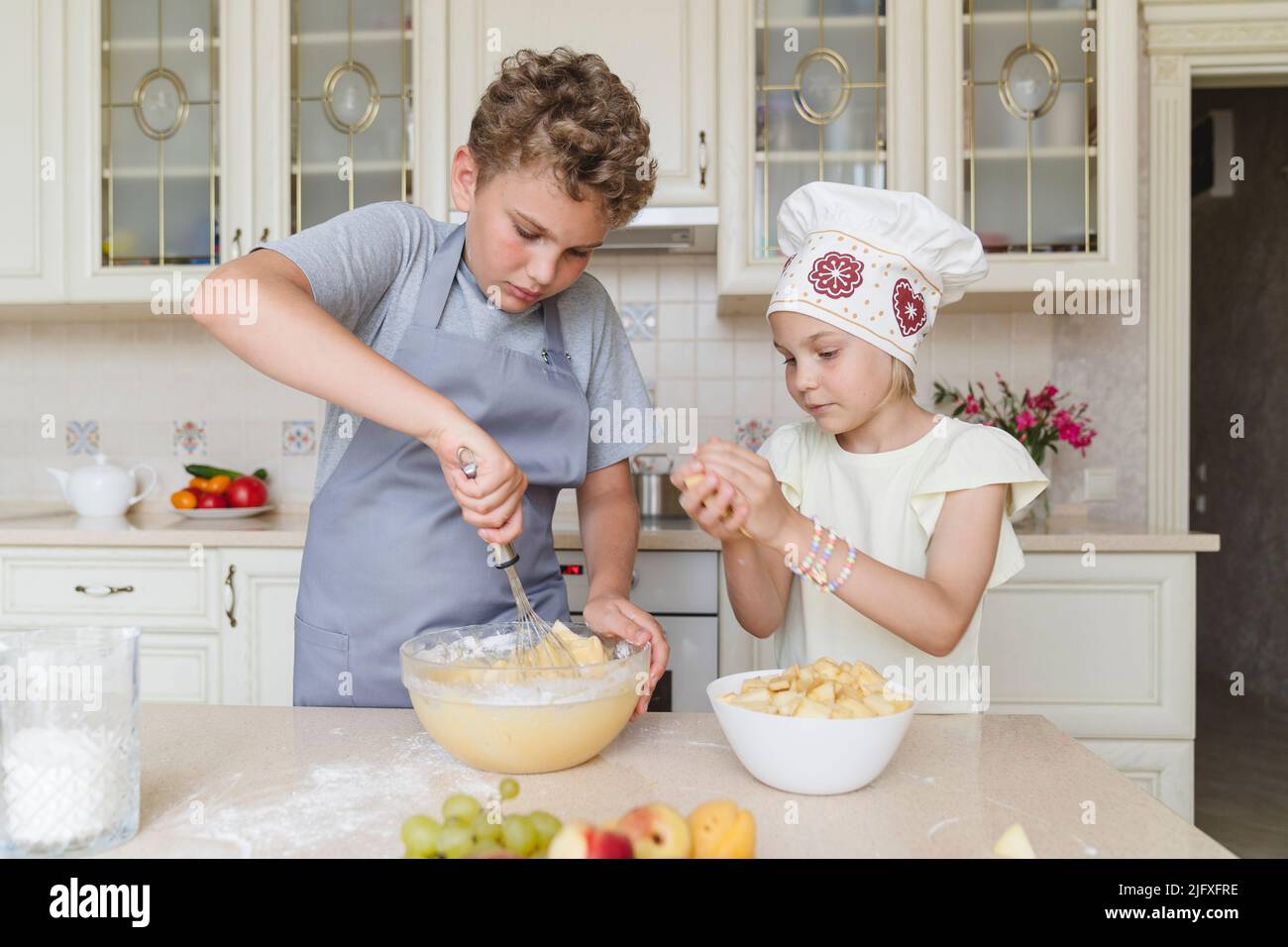 Les enfants de la cuisine cuisent une tarte aux pommes. Banque D'Images