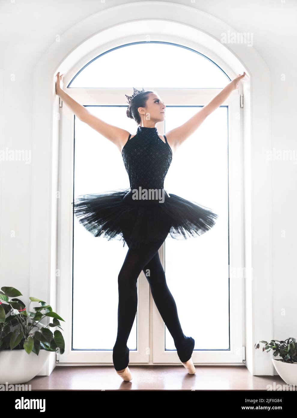 Jeune danseuse de ballet pratiquant avant la représentation en tutu noir, studio de danse classique, espace de copie Banque D'Images