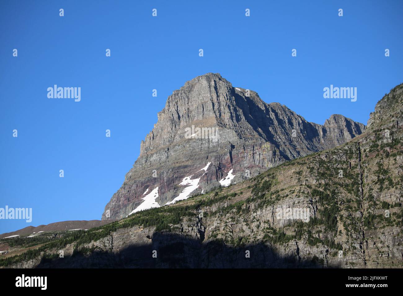 Parc national des Glaciers Montana USA - Logan Pass, en direction de Sun Rd, ciel bleu brillant au-dessus des majestueuses roches sédimentaires à bandes de couleur de Clements Mountain Banque D'Images