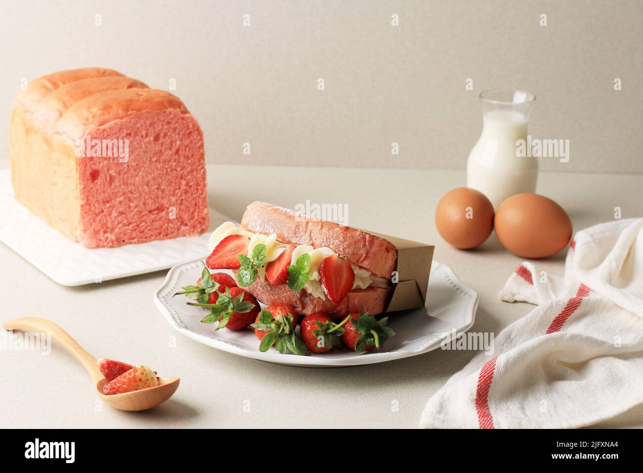 Sandwich au pain rose coréen avec fromage à la crème et fraise fraîche, servi avec du lait et des œufs durs. Japonais Sasando concept petit déjeuner sain Banque D'Images