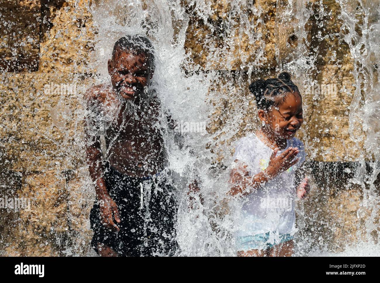 St. Louis, États-Unis. 05th juillet 2022. Les patinoires de Chaeuron (8) et Audrey Hardie (6) ont battu la chaleur de 100 degrés en se gardant au frais dans une chute d'eau au jardin de la ville de Saint-Louis, mardi, 5 juillet 2022. Un avertissement de chaleur excessive a été émis pour la région de Saint-Louis alors que les températures atteignent près de 100 avec des températures de 110 pour le reste de la semaine. Photo par Bill Greenblatt/UPI crédit: UPI/Alay Live News Banque D'Images