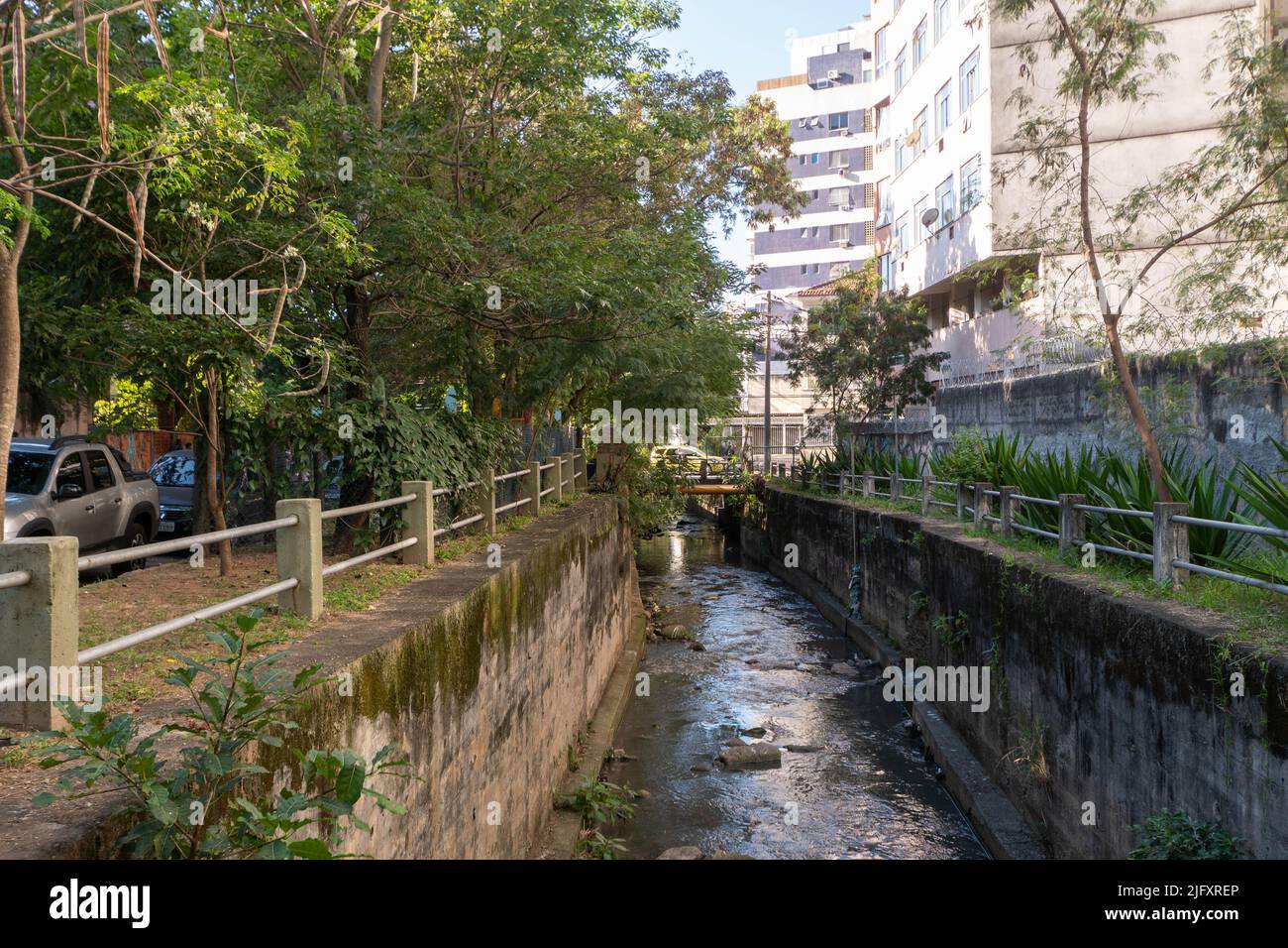 Vue sur la rivière Maracana qui est partiellement canalisée avec des arbres autour dans le quartier de Tijuca Banque D'Images