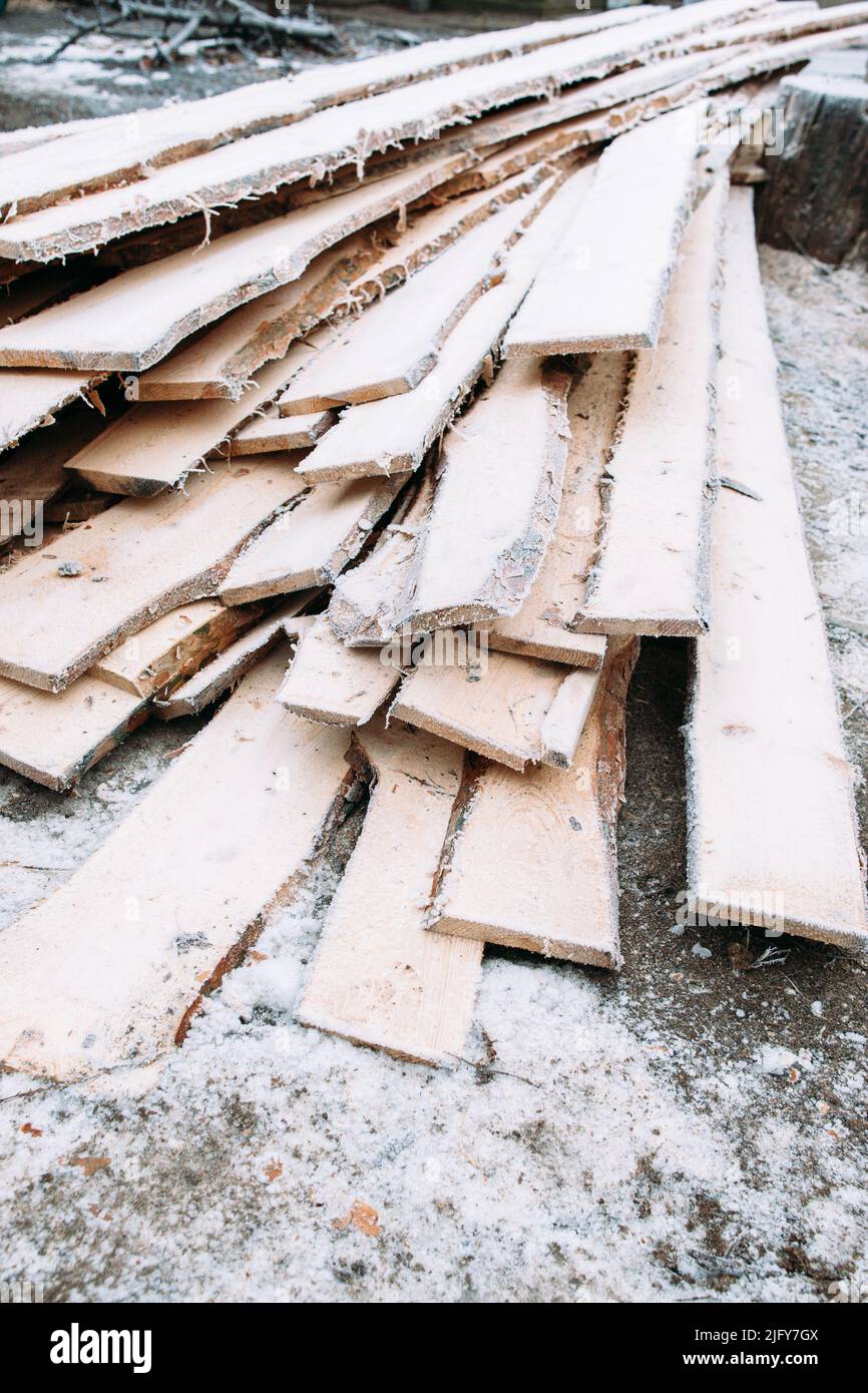 Un tas de planches couvraient des planches de bois dépolies enneigées Banque D'Images