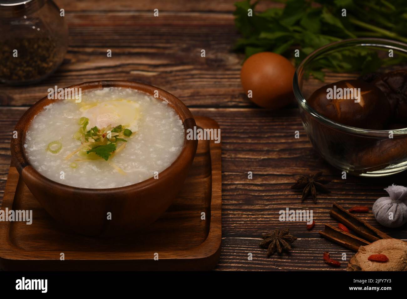 Bouillie de riz, bouillie de riz ou congee avec des ingrédients sur table en bois Banque D'Images