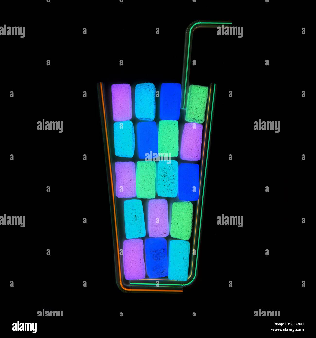 Cocktail de fête au néon effet club shake Flat-lay fait à partir de bonbons de gelée de fruits et de pailles à boire isolées sur fond noir. Banque D'Images