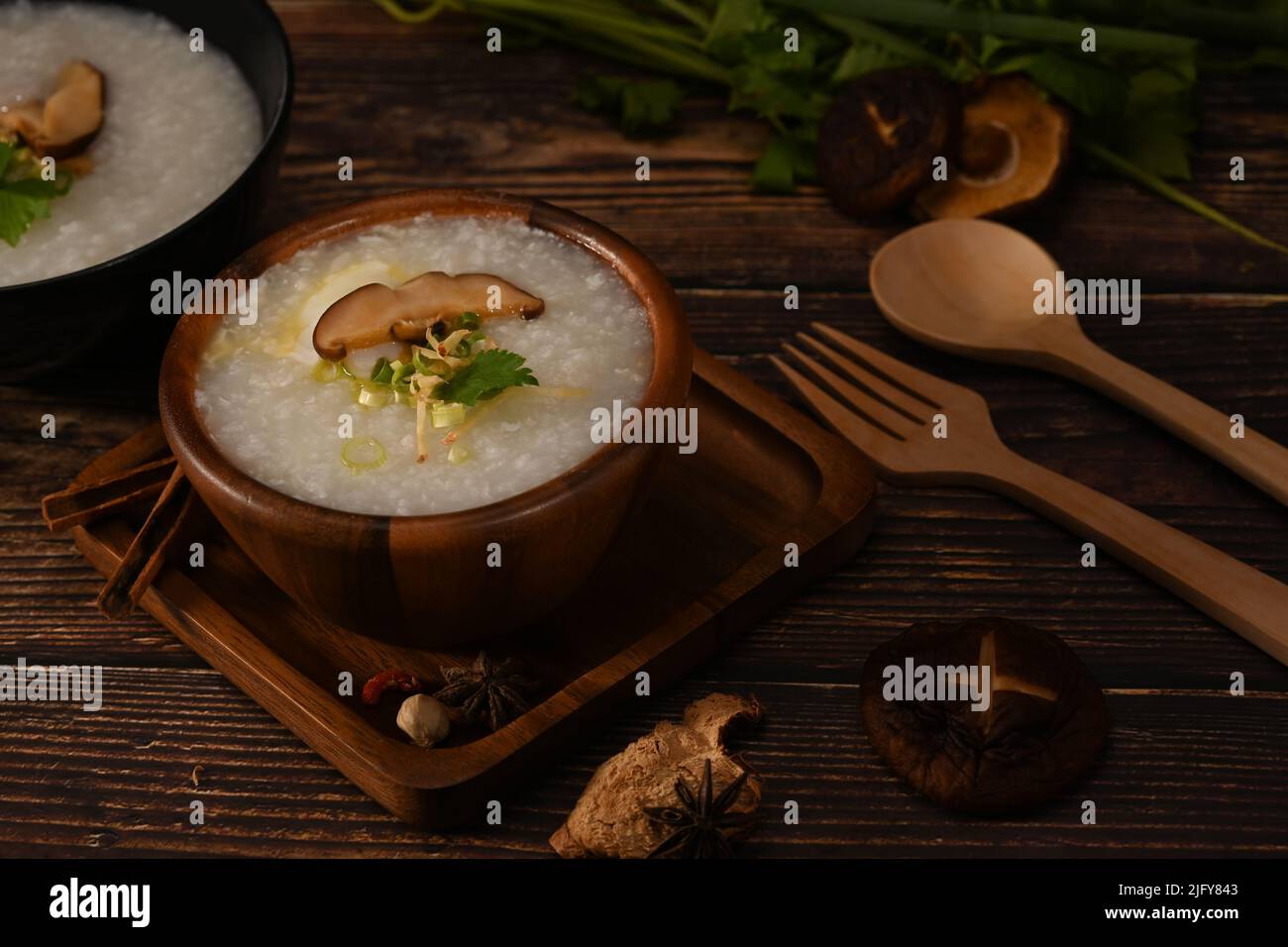 Porridge de riz, bouillie de riz ou congee avec champignons shiitake, tranche de gingembre et de scallion servis dans un bol en bois pour un repas léger Banque D'Images