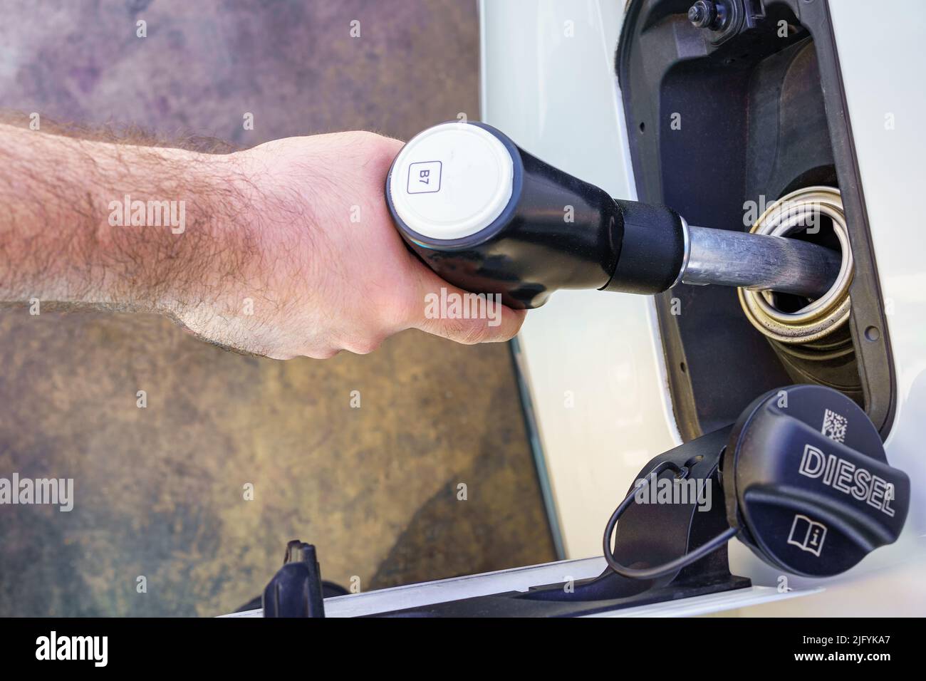 Main d'un homme ravitaillant avec le tuyau dans le réservoir d'une voiture. Banque D'Images