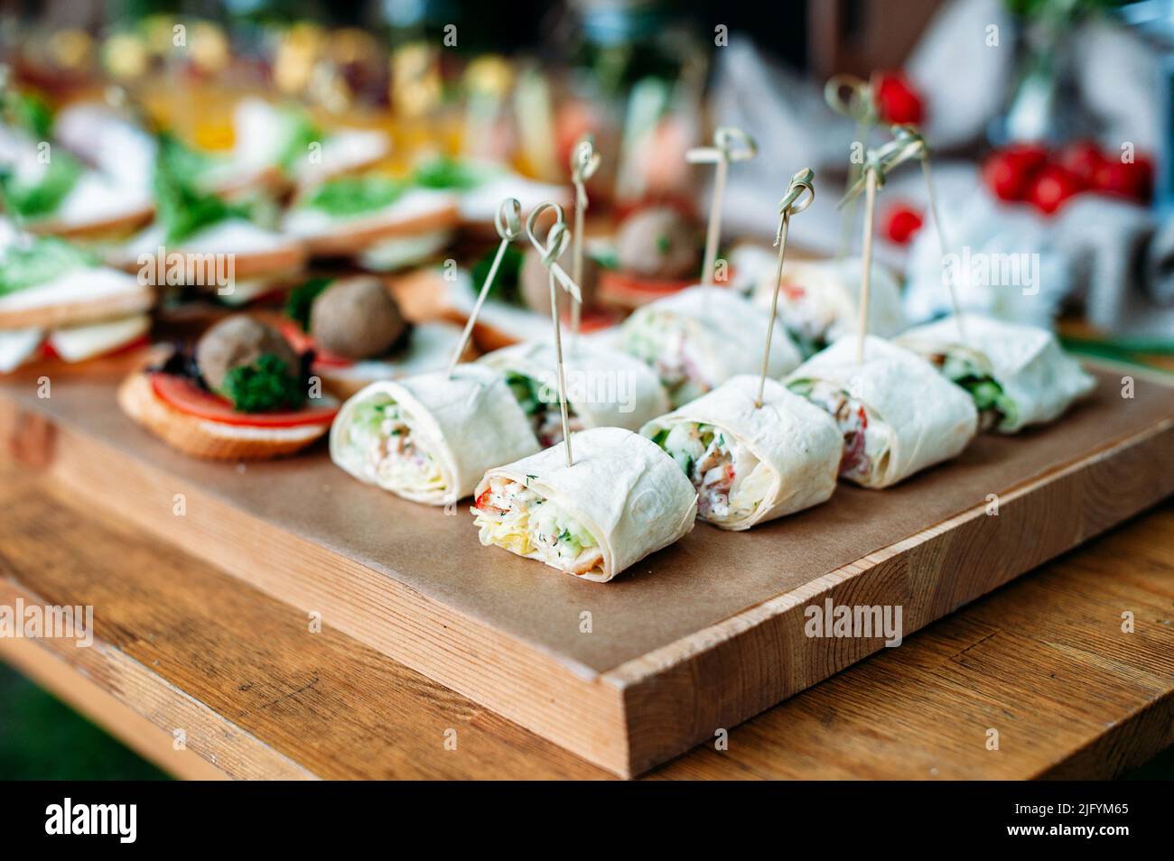 Délicieux buffet de restauration table de banquet décorée dans un style rustique dans le jardin. Différents en-cas, sandwichs avec jambon et sauce pesto. Extérieur, proche Banque D'Images