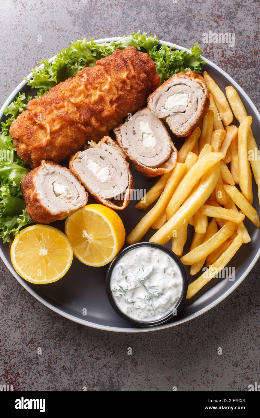 Karadjordjeva Schnitzel est un rouleau de porc farci de Kaymak, pané et frit, servi avec des frites et de la sauce tartare dans une assiette sur la ta Banque D'Images