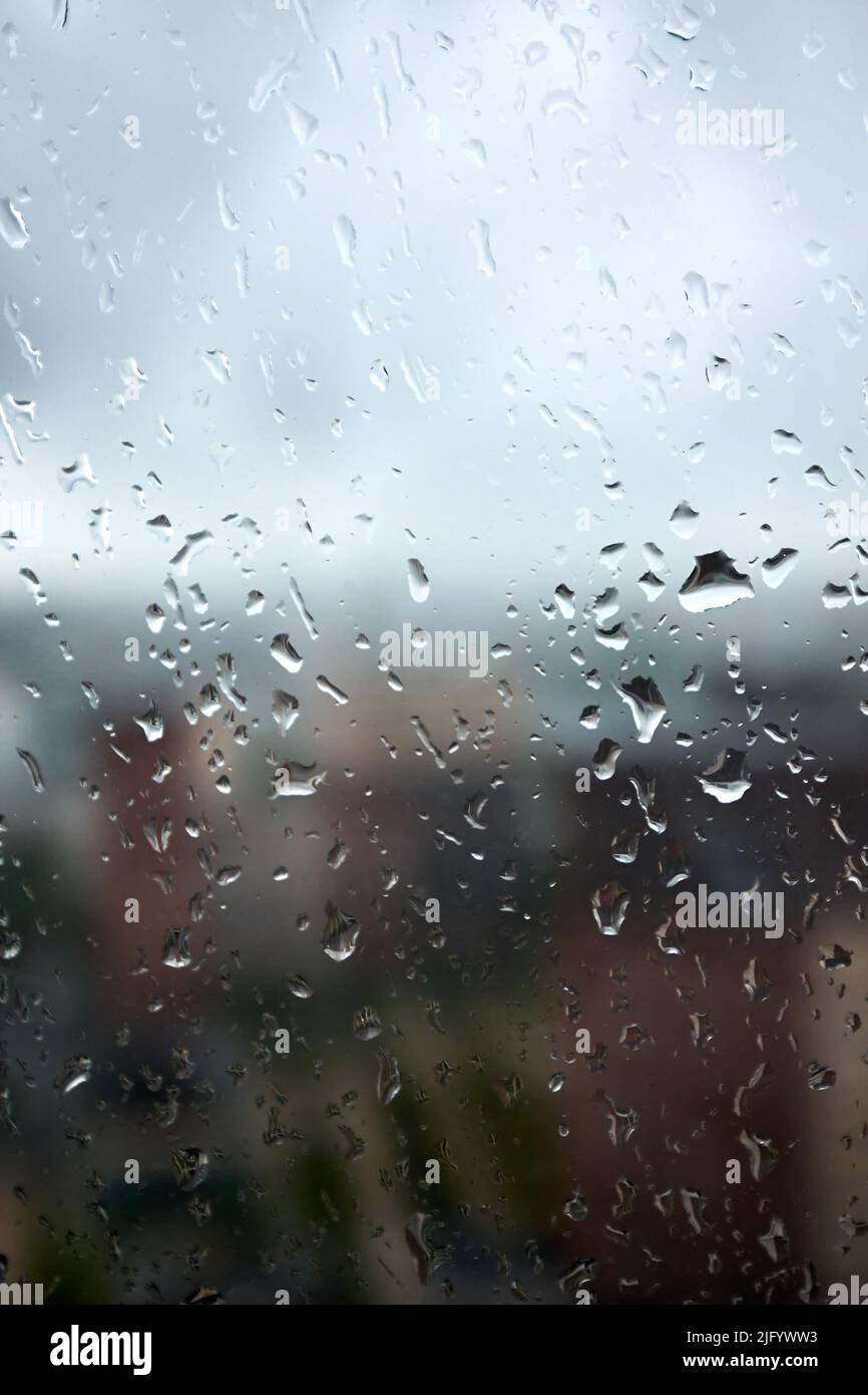 Les gouttes sur le verre lors d'un jour pluvieux et nuageux évoquent la mélancolie et la tristesse. Vue sur la ville depuis la fenêtre. Mise au point sélective Banque D'Images