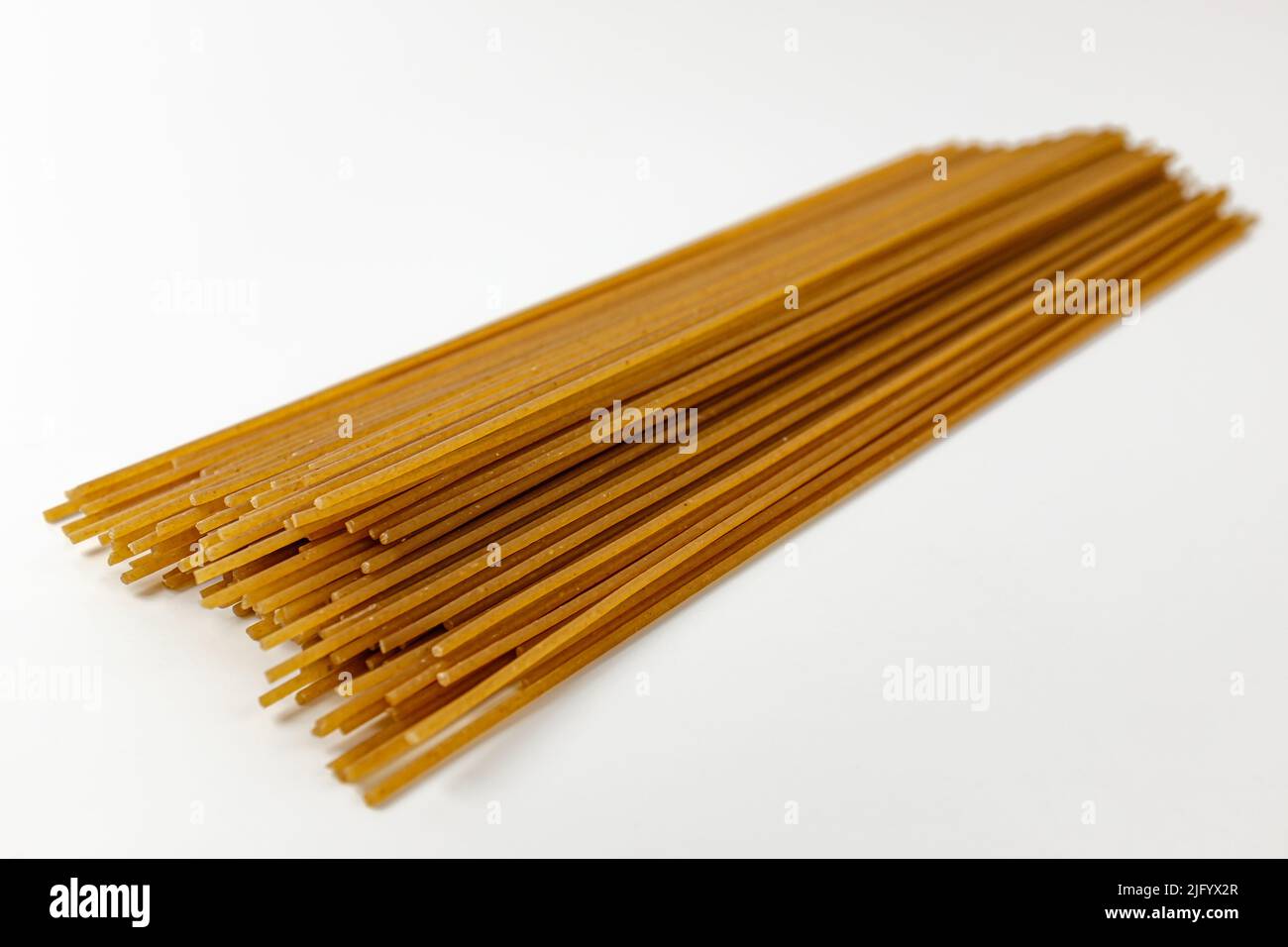 Spaghetti de blé entier sur fond blanc Banque D'Images