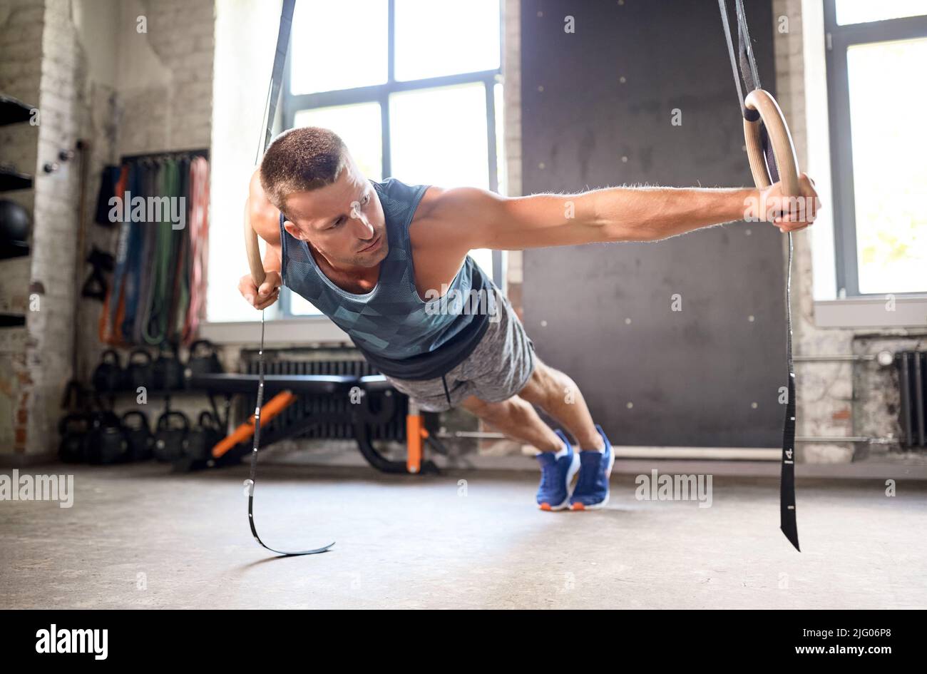 homme faisant de l'exercice sur les anneaux de gymnastique en salle de gym Banque D'Images