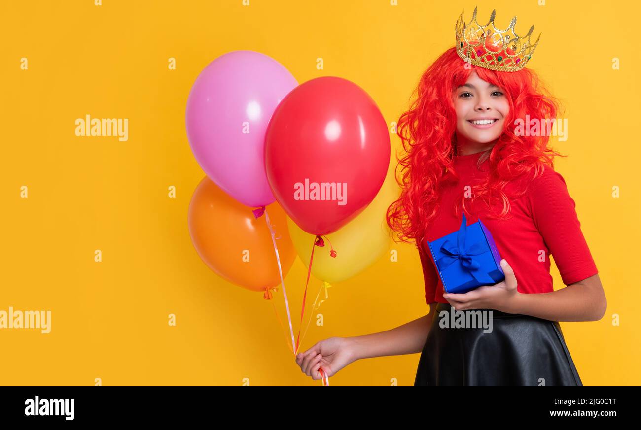 joyeux enfant dans la couronne avec le ballon présent et de fête sur fond jaune Banque D'Images joyeux enfant dans la couronne avec le ballon présent et de fête sur fond jaune Banque D'Images