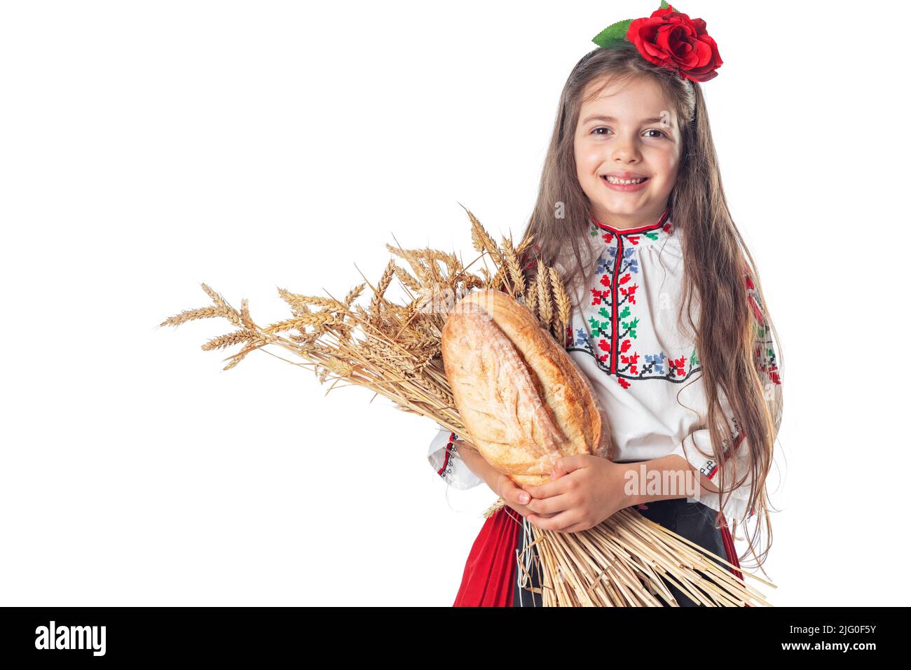 Portrait d'une belle fille en robe traditionnelle bulgare folklorique tenant du pain fait maison et du blé doré Banque D'Images