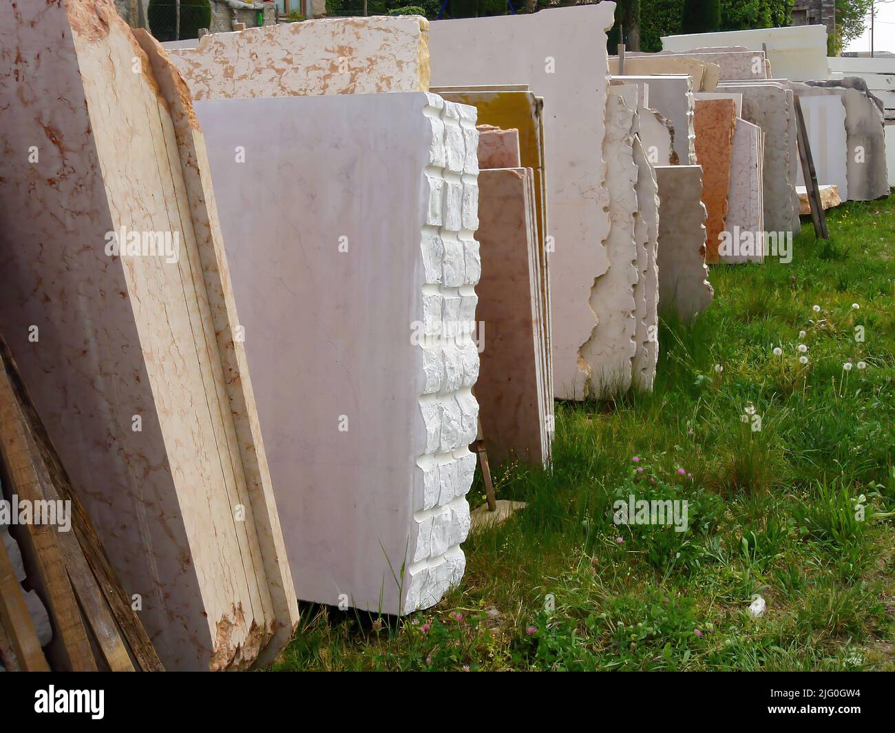 Une photo de différents types de blocs de pierre s'inclinant l'un sur l'autre sur l'herbe Banque D'Images