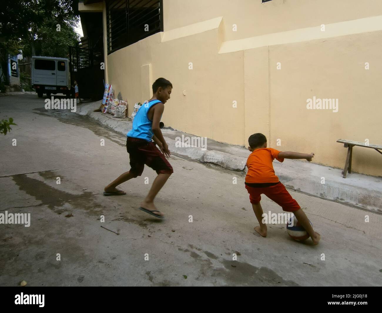 Deux jeunes garçons jouant au football dans la rue de San mateo Banque D'Images