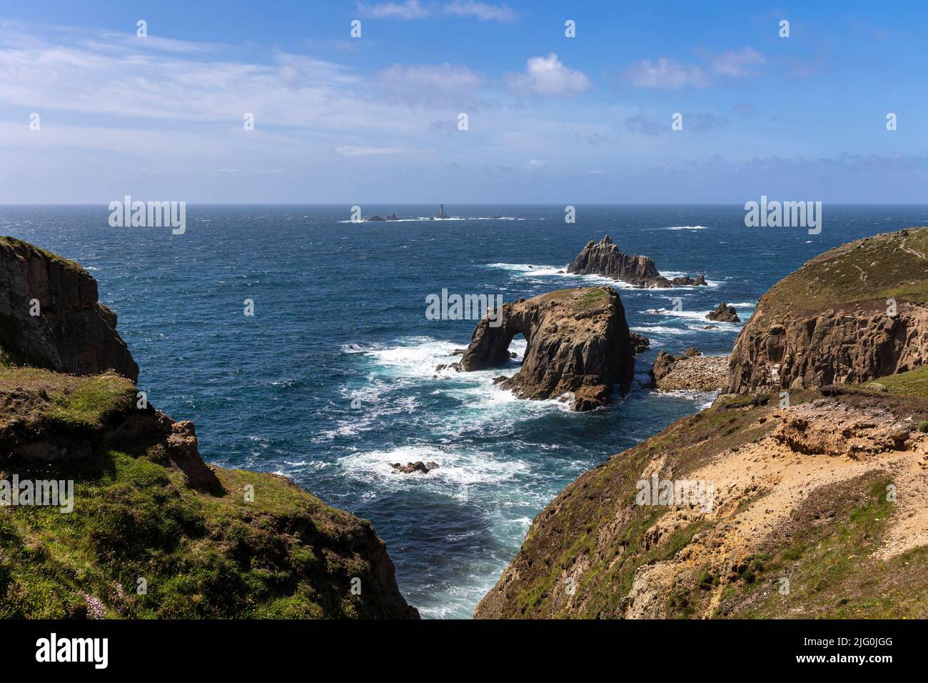 Sentier côtier vue à pied entre Gwennap Head et Lands End. Arc Enys Dodnan avec phare de Longships au loin Banque D'Images