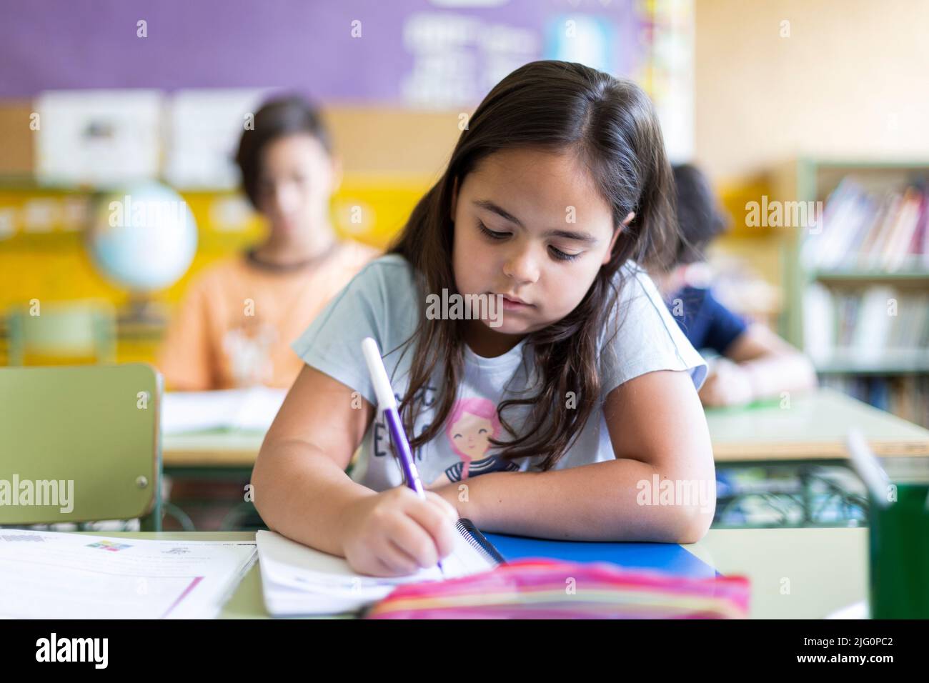 Petite fille de race blanche faisant ses devoirs à l'école. Concept d'apprentissage, d'éducation et de développement des enfants. Banque D'Images