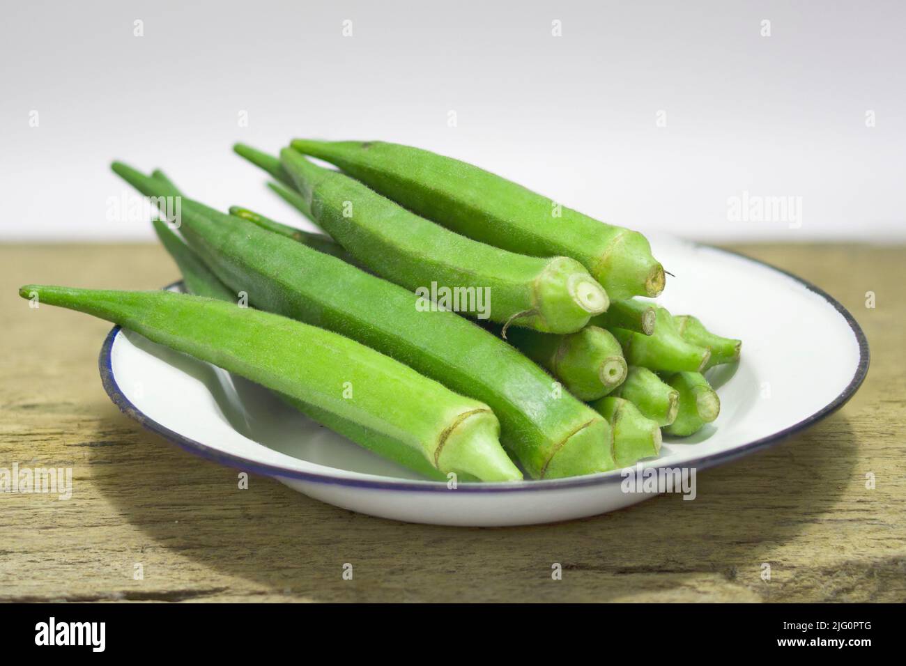 Gros plan sur des fruits okra frais (abelmoschus esculentus) sur fond de bois Banque D'Images