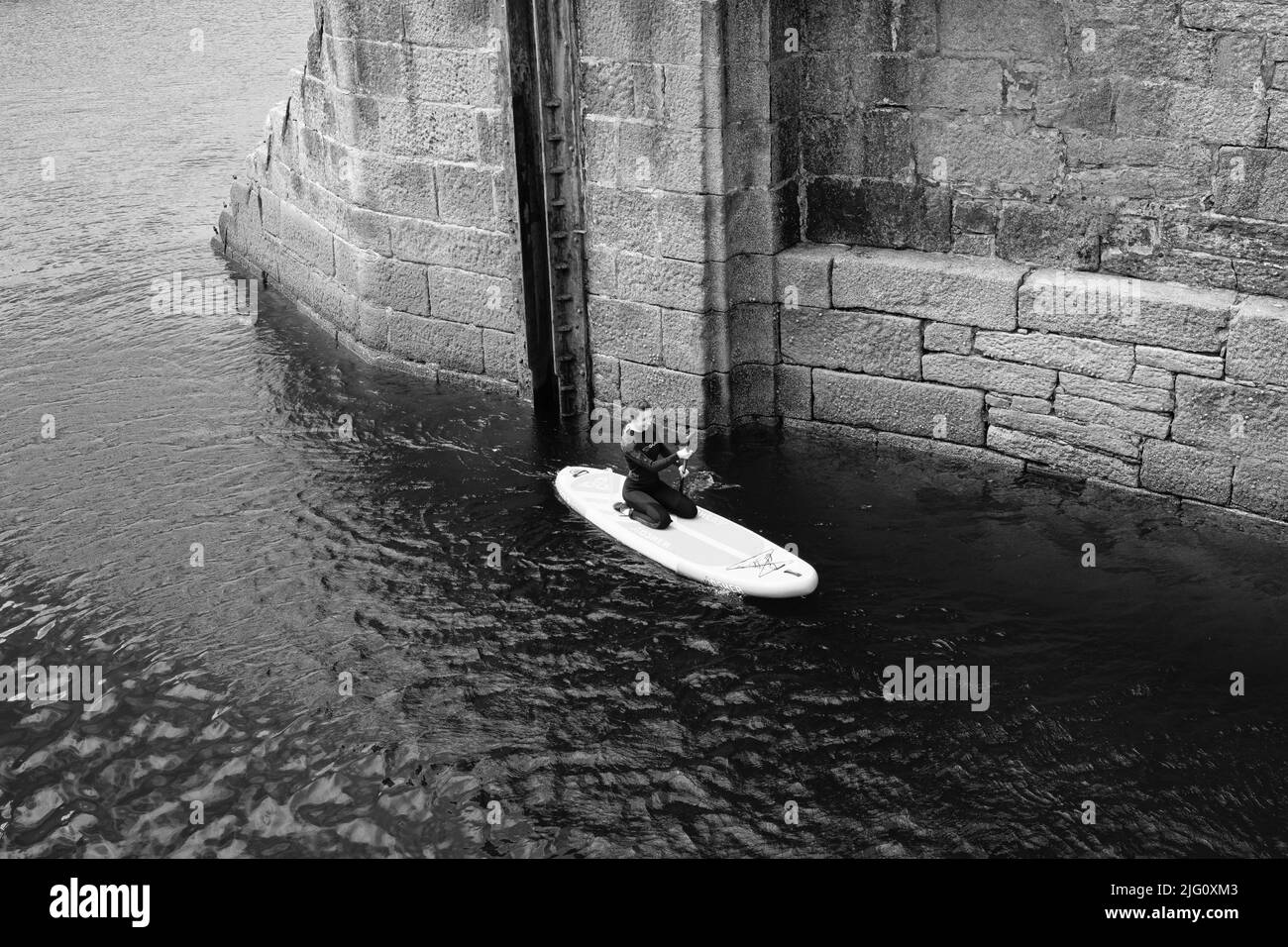 Paddleboard dans le port de Porthleven, Cornouailles Banque D'Images