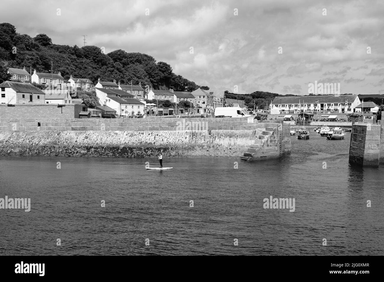 Paddleboard dans le port de Porthleven, Cornouailles Banque D'Images