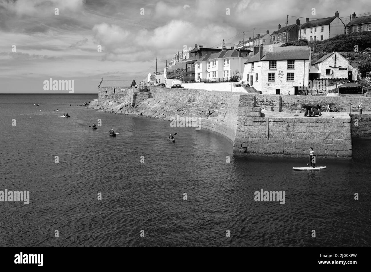 Paddleboard dans le port de Porthleven, Cornouailles Banque D'Images