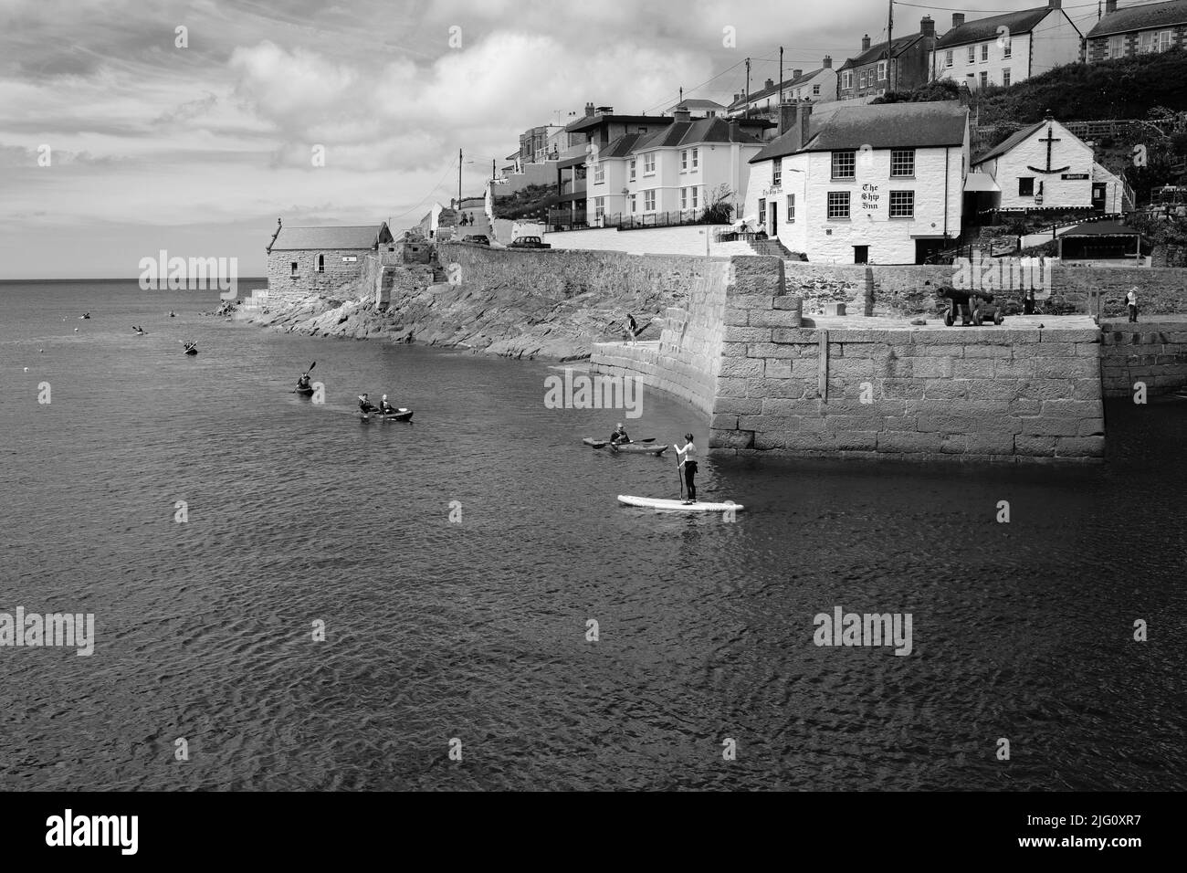 Paddleboard dans le port de Porthleven, Cornouailles Banque D'Images