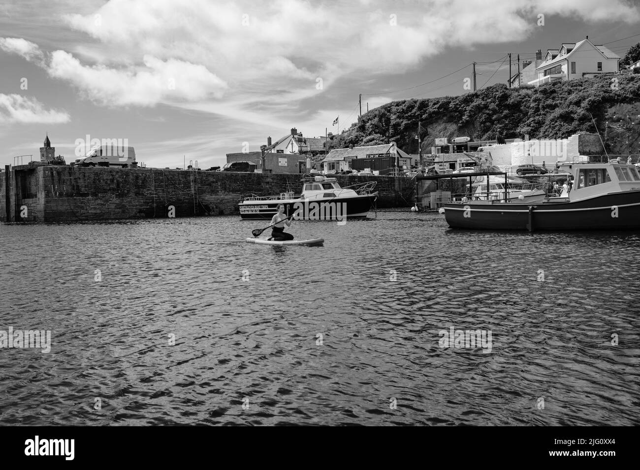 Paddleboard dans le port de Porthleven, Cornouailles Banque D'Images