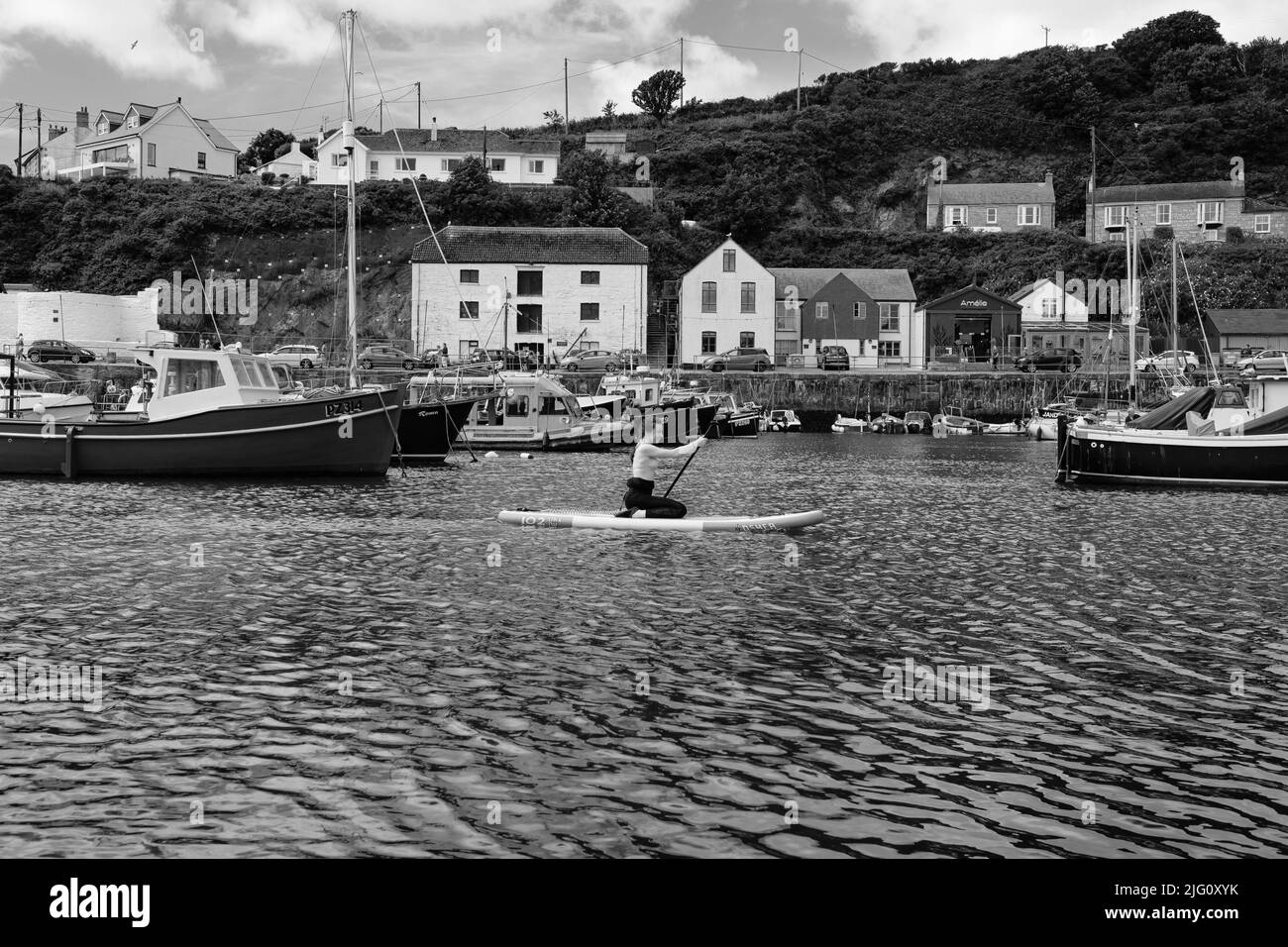 Paddleboard dans le port de Porthleven, Cornouailles Banque D'Images