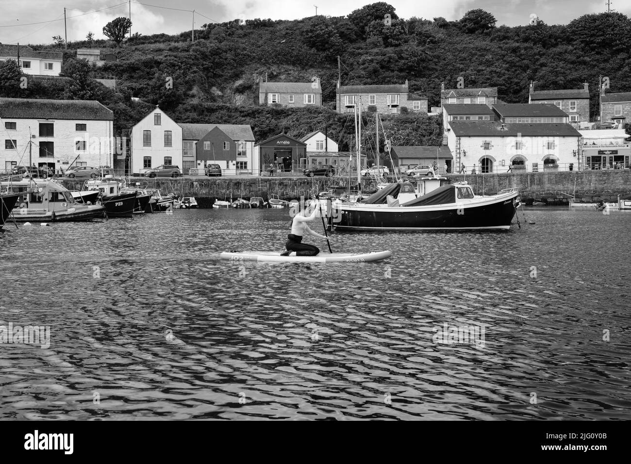 Paddleboard dans le port de Porthleven, Cornouailles Banque D'Images