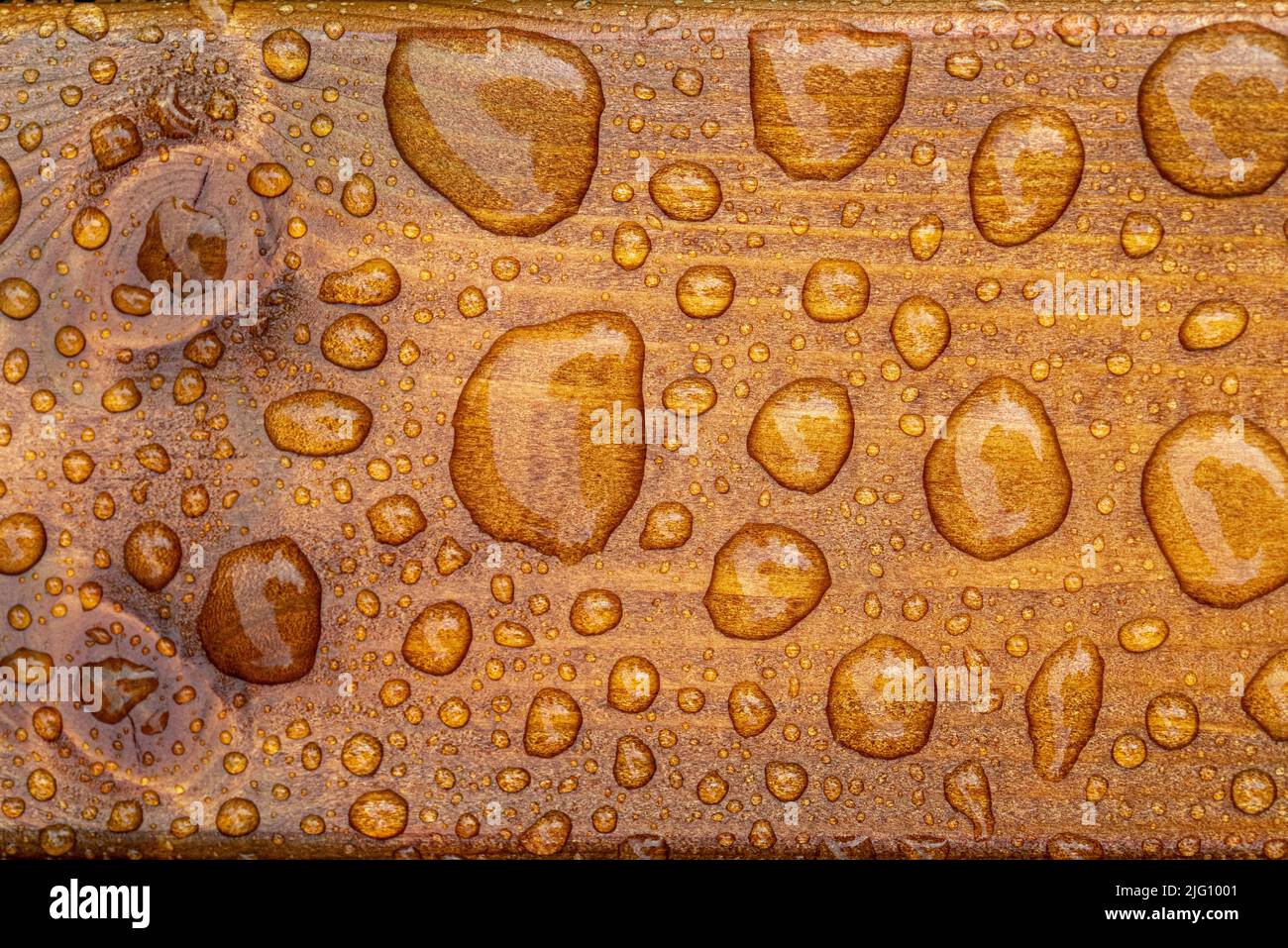 fond horizontal de texture laquée de bois brûlé avec des gouttes d'eau brillantes de la pluie, des planches de bois mouillées Banque D'Images