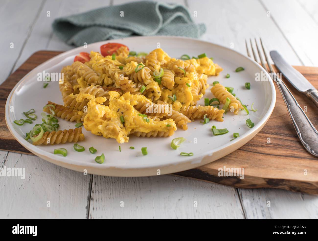 Remuez les nouilles de blé entier frites avec des œufs brouillés sur une assiette. Repas sain et bon marché Banque D'Images