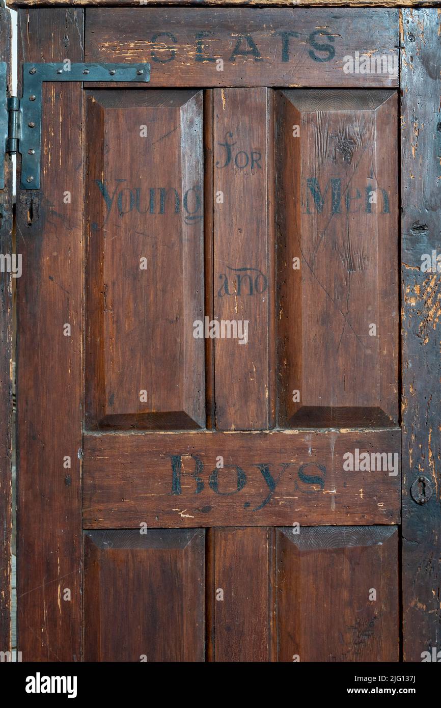 Porte dans des ragoûts de boîte étiquetés comme sièges pour les hommes et les garçons à All Saints Church, Laxfield, Suffolk Banque D'Images